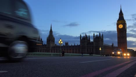 Traffic-passes-in-front-of-Big-Ben-and-Houses-Of-Parliament-in-London-England-at-night-1