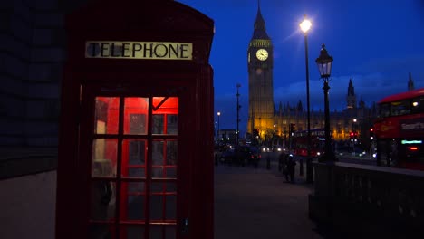 An-iconic-red-telephone-booth-in-front-of-Big-Ben-and-Houses-Of-Parliament-in-London-England-at-night