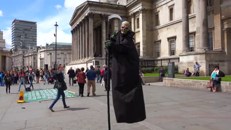 A-street-performer-plays-the-grim-reaper-at-Trafalgar-Square-London;-