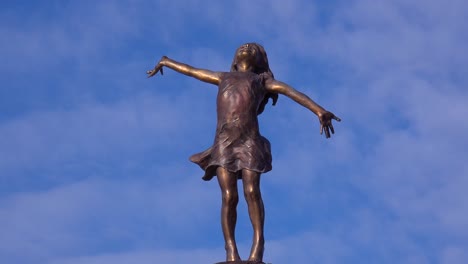 A-statue-of-a-young-girl-with-arms-wide-open-embracing-the-world-sits-in-a-Wisconsin-park