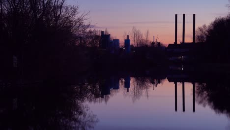 A-beautiful-sunset-over-a-lake-with-the-smokestacks-of-industry-background