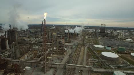 Excellent-aerial-over-huge-industrial-oil-refinery-with-gas-torch-burning