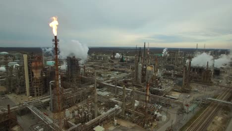 Excellent-aerial-over-huge-industrial-oil-refinery-with-gas-torch-burning-1