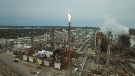 Excellent-aerial-over-huge-industrial-oil-refinery-with-gas-torch-burning-2