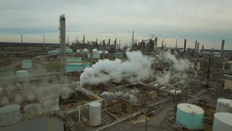 Excellent-aerial-over-huge-industrial-oil-refinery-with-smoke-and-pollutants-rising