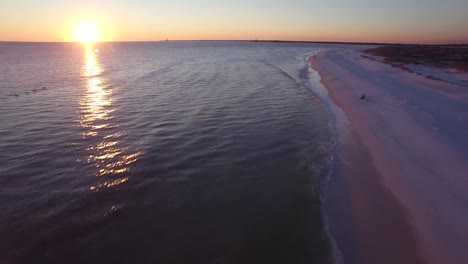 Eine-Schöne-Luftaufnahme-über-Weißen-Sandstränden-Bei-Sonnenuntergang-Nach-Pelikanen-In-Der-Nähe-Von-Pensacola-Florida