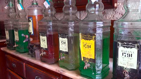 Antiguas-Botellas-De-Aceites-Y-Perfumes-Se-Alinean-En-Un-Puesto-De-Tienda-En-La-Ciudad-Vieja-De-La-Habana,-Cuba