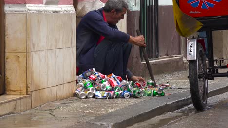Ein-Mann-Auf-Der-Straße-Zerquetscht-Und-Recycelt-Aluminiumdosen-In-Havanna,-Kuba