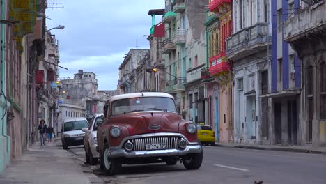 Great-shot-of-crowded-streets-and-alleys-of-the-old-city-of-Havana-Cuba-with-classic-old-car-foreground