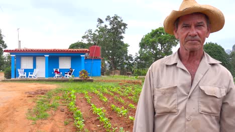 Un-Agricultor-Cubano-Se-Encuentra-Frente-A-Una-Casa-De-Campo-En-Una-Finca-De-Tabaco-En-Viñales,-Cuba