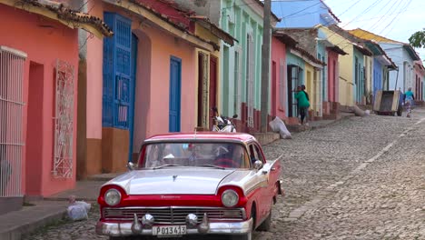 A-beautiful-shot-of-the-buildings-and-cobblestone-streets-of-Trinidad-Cuba-with-old-classic-car-passing-1