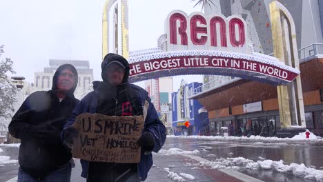 Two-homeless-veterans-stand-in-front-of-the-Reno-arch-begging-for-money