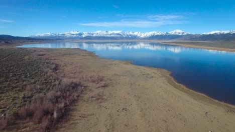 Eine-Wunderschöne-Antenne-über-Einem-Bergsee-Zeigt-Die-Sierra-Nevada-Im-Winter-Mit-Reichlich-Wasser