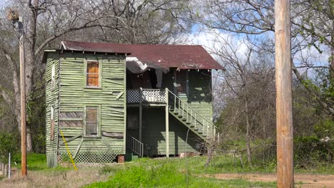 A-decaying-old-tenement-house-sits-in-a-field-in-Jackson-Mississippi