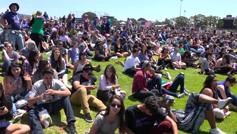 Attendees-at-a-Bernie-Sanders-rally-sit-on-a-hillside-1