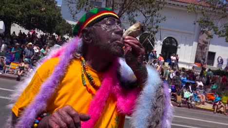 A-man-smokes-a-large-marijuana-joint-on-the-streets-of-Santa-Barbara-California-during-the-solstice-parade