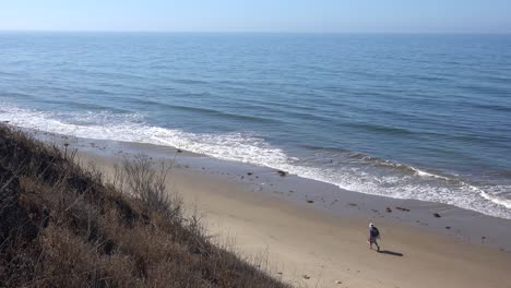 A-man-walks-along-a-lonely-beach-in-California