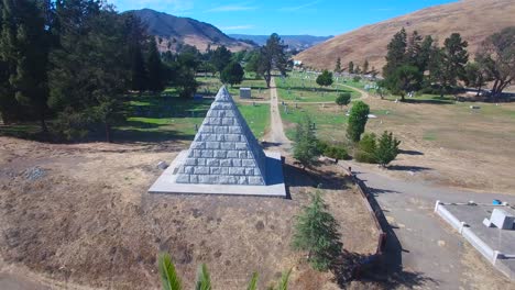 An-aerial-shot-over-a-large-stone-pyramid-in-a-cemetery-near-San-Luis-Obispo-California
