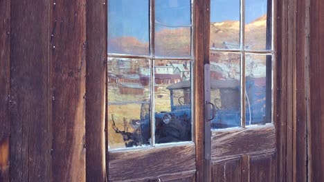 Reflection-in-old-glass-windows-reveals-the-abandoned-ghost-town-of-Bodie-California