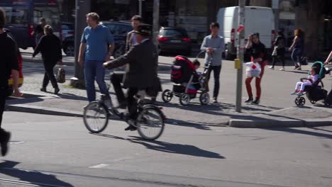 An-old-man-rides-a-very-small-bicycle-through-downtown-Munich-Germany