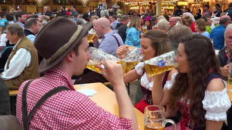 People-toast-with-large-beer-mugs-at-Oktoberfest-in-Germany