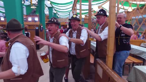 Drunken-men-celebrate-and-dance-in-a-beer-hall-during-Oktoberfest-in-Germany