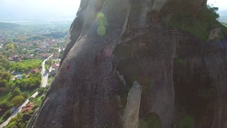 Beautiful-aerial-as-climbers-ascend-a-sheer-rocky-cliff-face-in-Meteora-Greece