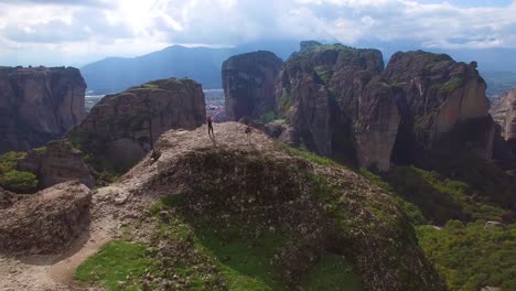 Beautiful-aerial-over-two-people-taking-photos-atop-the-rock-formations-of-Meteora-Greece