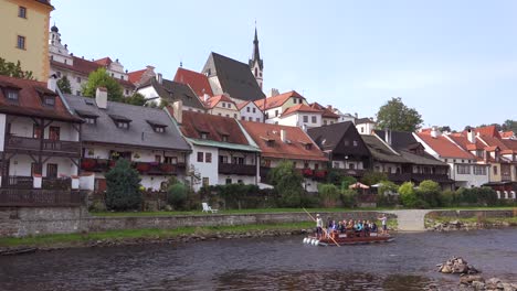 A-small-raft-travels-down-a-river-in-Cesk___´©-Krumlov-a-lovely-small-Bohemian-village-in-the-Czech-Republic