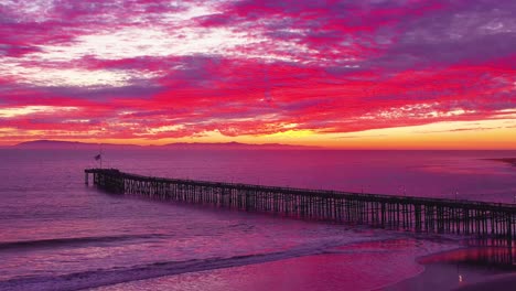 An-astonishing-sunset-aerial-shot-over-a-long-pier-and-the-Pacific-Ocean-and-Channel-Islands-in-Ventura-Southern-California