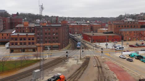 Imágenes-Aéreas-De-Drones-De-Un-Tren-De-Pasajeros-De-Amtrak-Que-Llega-A-Una-Pequeña-Ciudad-Americana-Burlington-Iowa