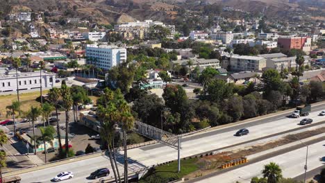 A-drone-aerial-of-Southern-California-beach-town-of-Ventura-California-with-freeway-foreground-and-mountains-background-2
