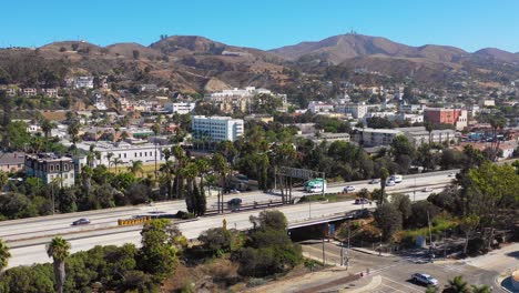 A-drone-aerial-of-Southern-California-beach-town-of-Ventura-California-with-freeway-foreground-and-mountains-background-3