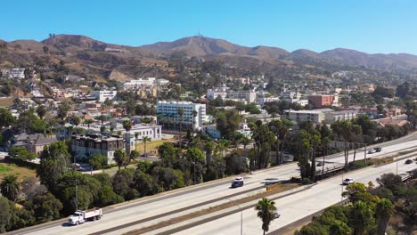 A-drone-aerial-of-Southern-California-beach-town-of-Ventura-California-with-freeway-foreground-and-mountains-background-4