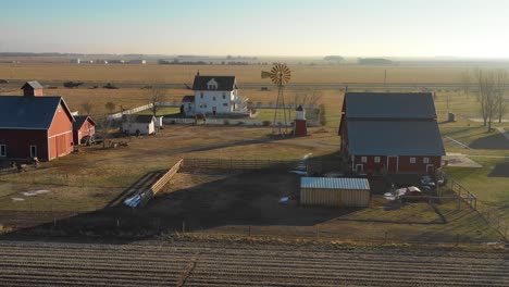 A-drone-aerial-establishing-shot-of-a-classic-farmhouse-farm-and-barns-in-rural-midwest-America-York-Nebraska