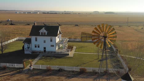 A-drone-aerial-establishing-shot-of-a-classic-farmhouse-farm-and-barns-in-rural-midwest-America-York-Nebraska-1