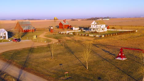 A-drone-aerial-establishing-shot-over-a-classic-farmhouse-farm-and-barns-in-rural-midwest-America-York-Nebraska-1