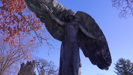 A-spooky-Halloween-giant-angel-statue-guards-a-cemetery-or-graveyard-in-this-haunted-image