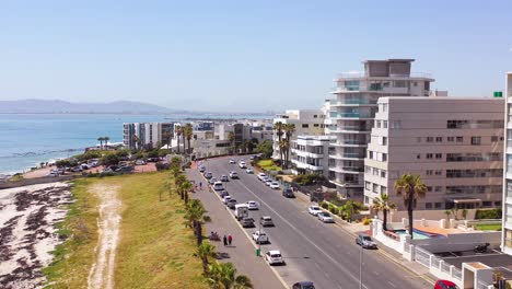 Antenne-Entlang-Der-Küste-Von-Kapstadt-Südafrika-Mit-Wohnungen-Und-Einer-Belebten-Straße