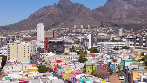 Tilt-down-aerial-reveals-colorful-Bo-kaap-Cape-Town-neighborhood-and-downtown-city-skyline