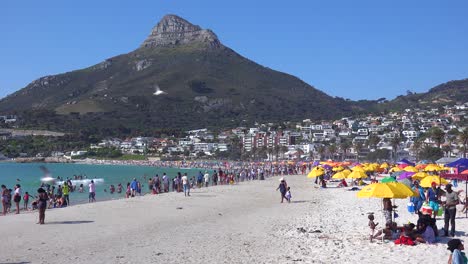 A-crowded-and-busy-holiday-beach-scene-at-Camps-Bay-Cape-Town-South-Africa-with-Lion's-Head-mountain-in-background-1