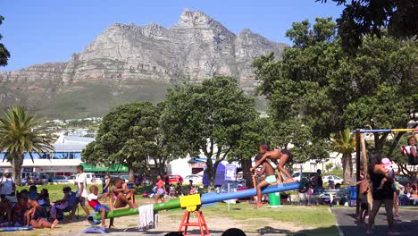 Kinder-Spielen-Auf-Einer-Wippe-Auf-Einem-Spielplatz-In-Camps-Bay-Cape-Town-Südafrika-Mit-Tafelberg-Hintergrund