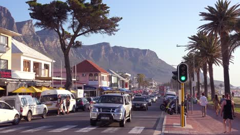 Good-establishing-shot-of-road-through-Camps-Bay-Cape-Town-South-Africa-with-cars-and-tourist-traffic