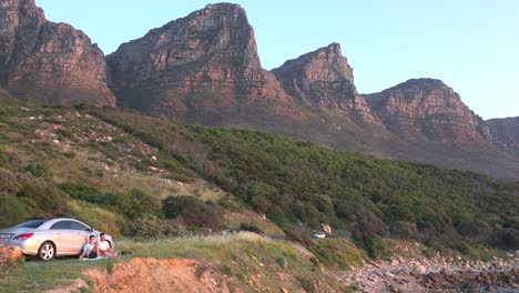 People-picnic-at-sunset-beneath-the-Twelve-Apostle-mountains-near-Camps-Bay-Cape-Town-South-Africa