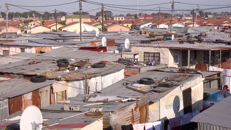 Schwenk-über-Die-Dächer-Eines-Typischen-Townships-In-Südafrika-Gugulethu-Mit-Blechhütten-Arme-Leute-Und-Armut
