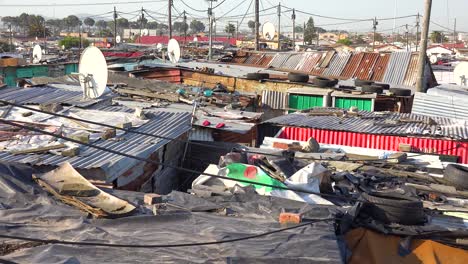 Establishing-shot-across-rooftops-of-a-typical-township-in-South-Africa-Gugulethu-with-tin-huts-poor-people-and-poverty