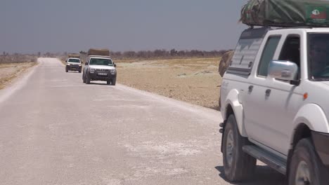 An-elephant-is-seen-along-the-road-with-safari-vehicles-passing-in-Etosha-National-Park-Namibia