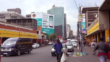 People-walk-on-the-streets-in-the-downtown-business-district-of-Johannesburg-South-Africa-with-garbage-and-trash-around