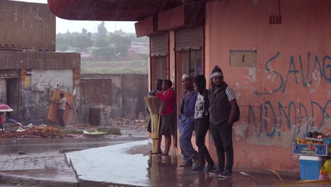 People-wait-in-the-rain-on-a-street-corner-in-Soweto-Township-South-Africa