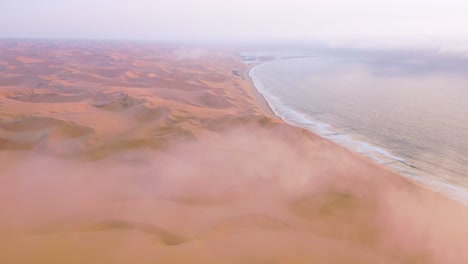 Gute-Hohe-Luftaufnahme-Durch-Wolken-Und-Nebel-über-Den-Weiten-Sanddünen-Der-Namibwüste-Entlang-Der-Skelettküste-Namibias